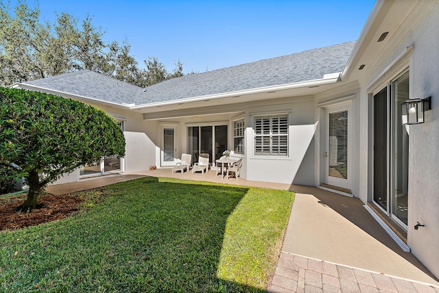 back of property featuring a lawn and a patio area