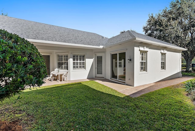 rear view of house featuring a lawn and a patio