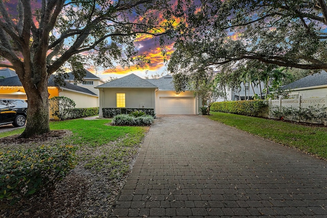 view of front of property with a garage and a lawn