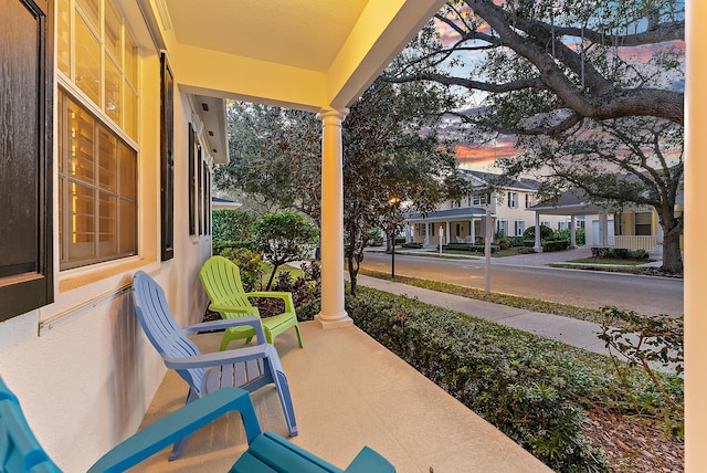 patio terrace at dusk featuring a porch