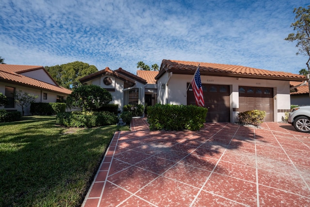 mediterranean / spanish house featuring a garage and a front yard