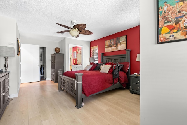 bedroom featuring a textured ceiling, light hardwood / wood-style floors, and ceiling fan