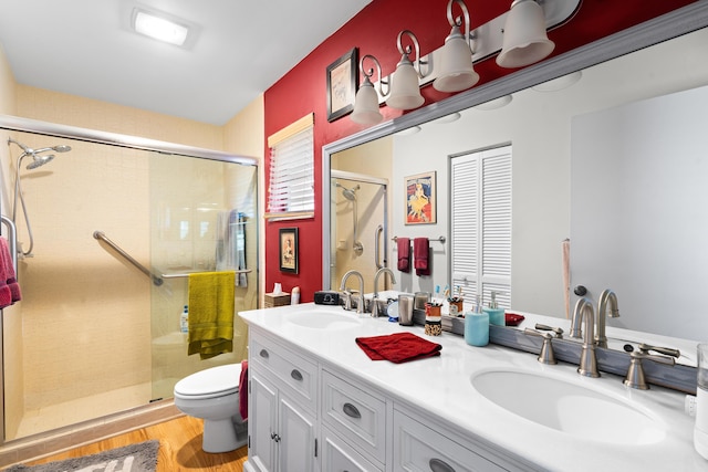 bathroom with vanity, hardwood / wood-style flooring, toilet, and a shower with shower door