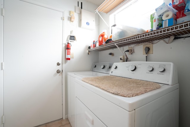 washroom with light tile patterned flooring and washing machine and clothes dryer