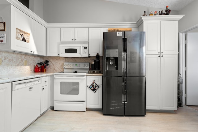 kitchen with white cabinets, a textured ceiling, white appliances, and backsplash