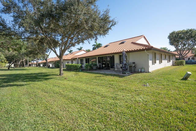 rear view of house featuring a yard and a patio