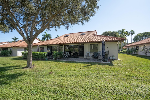 rear view of property with a lawn and a patio