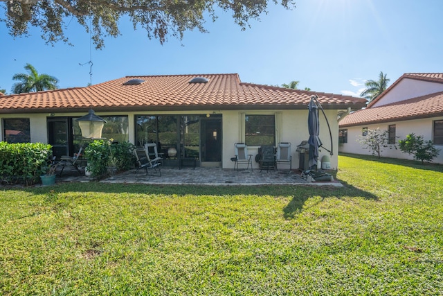 rear view of property with a yard and a patio