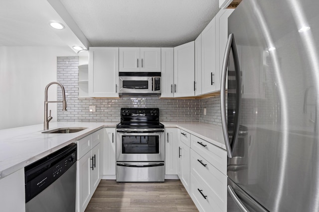 kitchen featuring decorative backsplash, sink, white cabinets, and stainless steel appliances