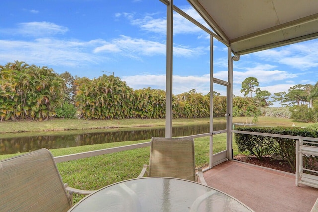 sunroom / solarium featuring a water view