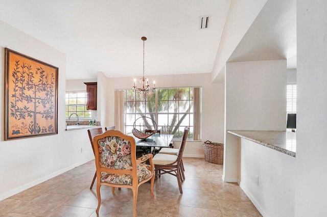 tiled dining space featuring an inviting chandelier