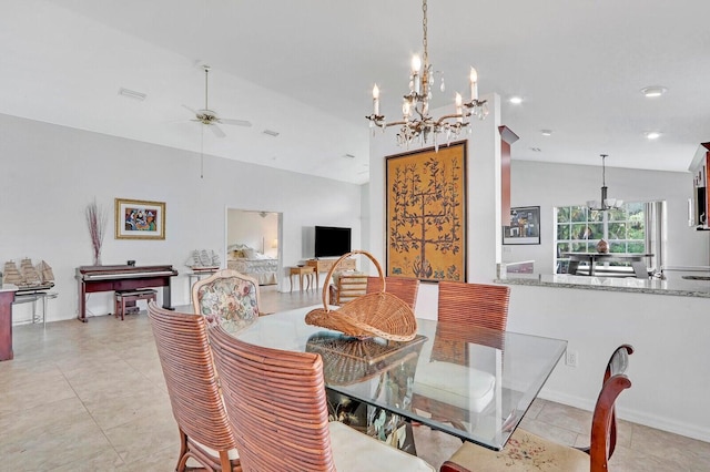 tiled dining room featuring ceiling fan with notable chandelier and vaulted ceiling