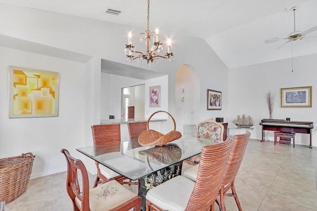 dining room with ceiling fan with notable chandelier, light tile patterned flooring, and lofted ceiling