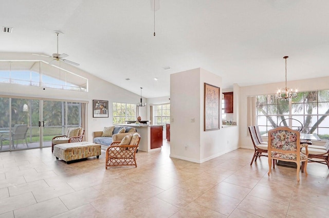 living room with ceiling fan with notable chandelier, a healthy amount of sunlight, light tile patterned flooring, and lofted ceiling