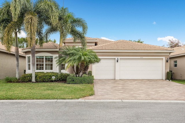 mediterranean / spanish house featuring a front lawn and a garage