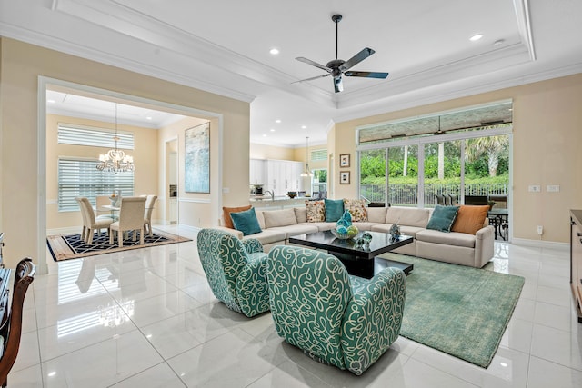 tiled living room with ceiling fan with notable chandelier, a tray ceiling, and ornamental molding