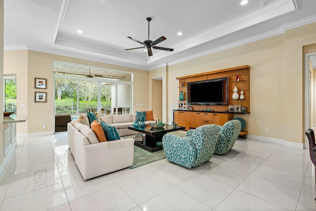 tiled living room with a raised ceiling, ceiling fan, and ornamental molding