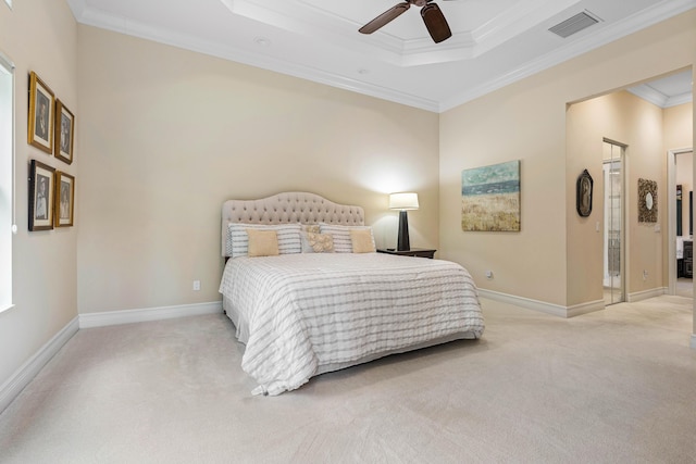 bedroom with ceiling fan, light colored carpet, a tray ceiling, and crown molding