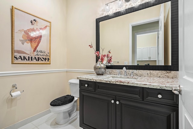 bathroom with toilet, vanity, and tile patterned flooring