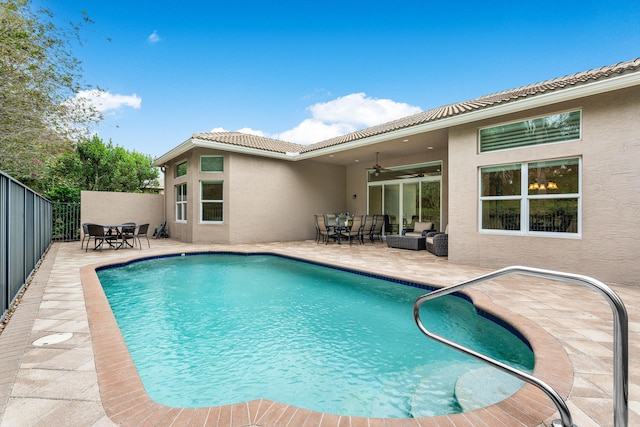 view of swimming pool featuring ceiling fan and a patio area