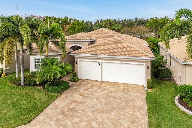 mediterranean / spanish home with a front lawn and a garage