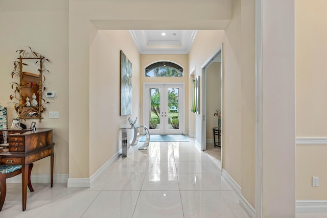 foyer entrance featuring a raised ceiling, french doors, and ornamental molding