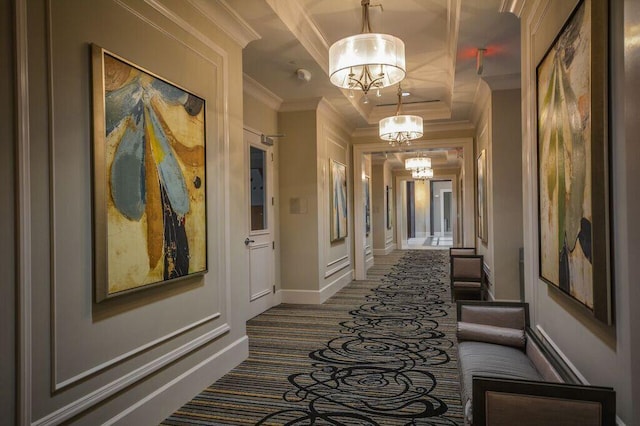 hall with ornamental molding and a notable chandelier