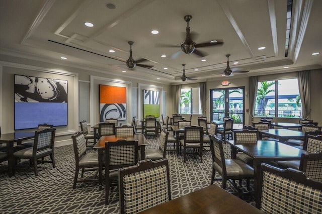 carpeted dining space featuring ceiling fan, a healthy amount of sunlight, and a tray ceiling