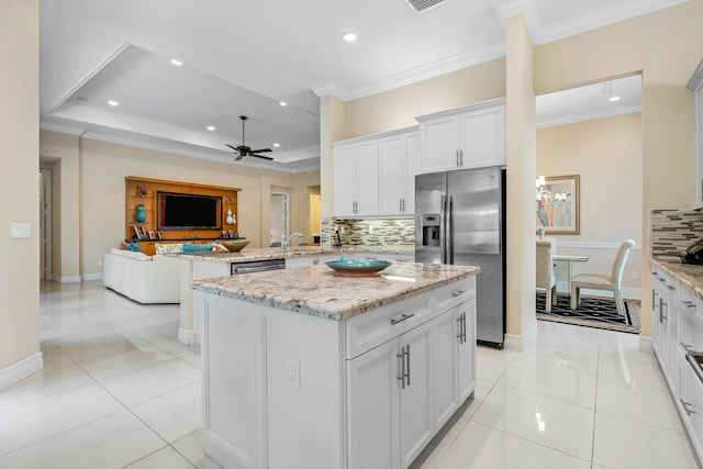 kitchen featuring white cabinets, decorative backsplash, appliances with stainless steel finishes, and a kitchen island