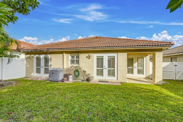 rear view of house featuring a yard, french doors, and central air condition unit