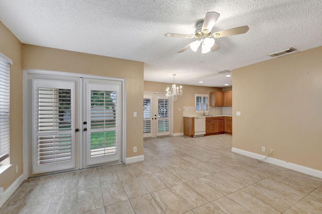 unfurnished living room featuring french doors, sink, light tile patterned flooring, a textured ceiling, and ceiling fan with notable chandelier