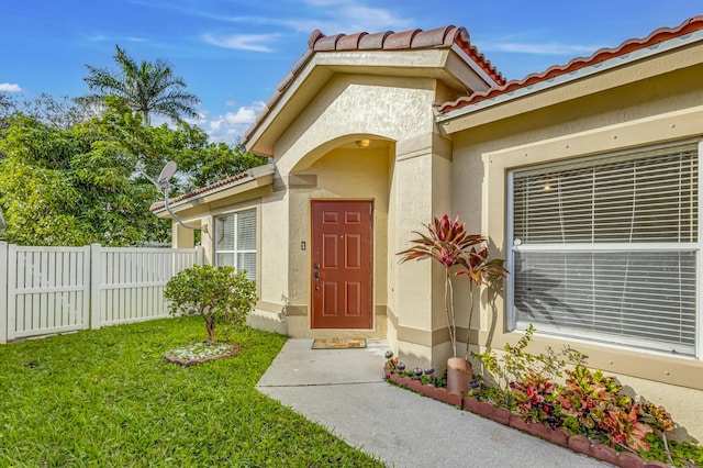 view of exterior entry with a yard