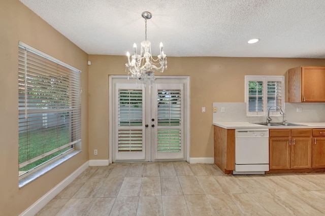 kitchen with a textured ceiling, decorative light fixtures, french doors, sink, and white dishwasher