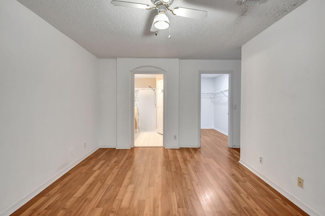 interior space featuring ceiling fan, a textured ceiling, and light wood-type flooring