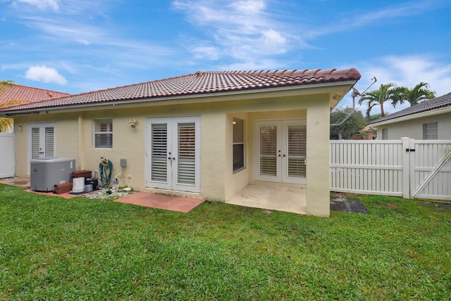 back of house featuring central air condition unit, a yard, french doors, and a patio