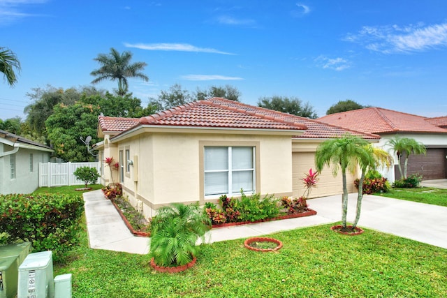 view of front of property with a garage and a front lawn