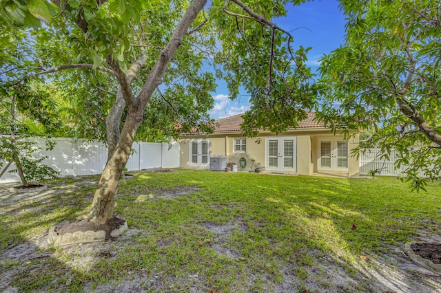 back of house featuring a yard, french doors, and central air condition unit