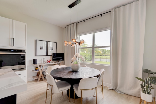 dining space with light hardwood / wood-style flooring and a chandelier