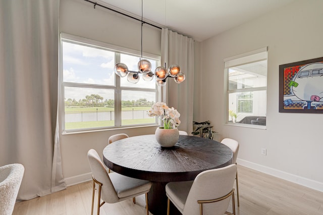 dining space featuring light wood-type flooring and an inviting chandelier