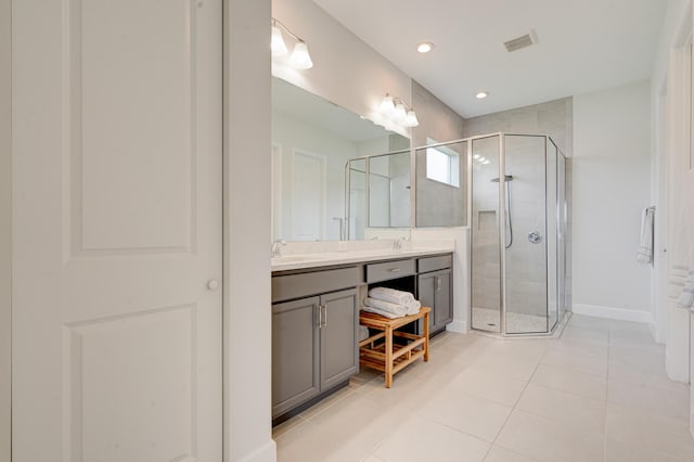 bathroom featuring a shower with door, vanity, and tile patterned flooring