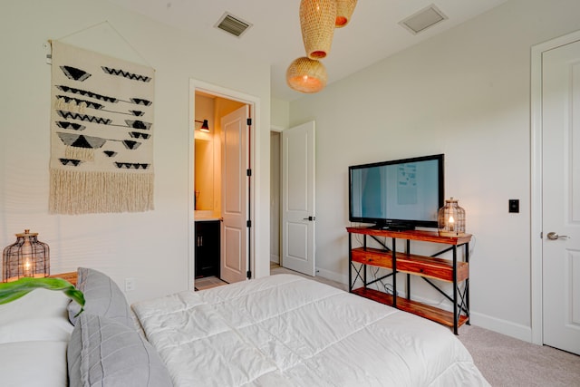 carpeted bedroom featuring ensuite bath