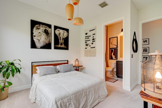 bedroom featuring light carpet and ensuite bathroom