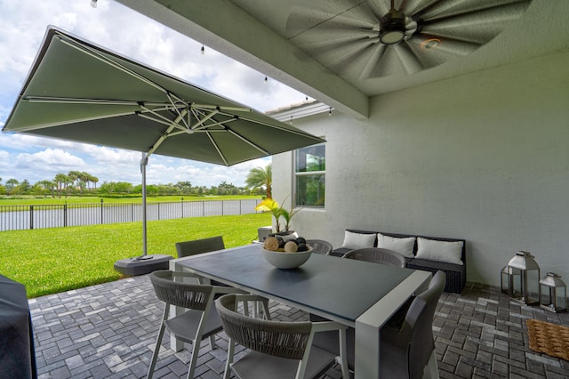 view of patio / terrace featuring ceiling fan and a water view