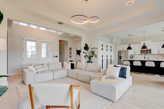 living room with an inviting chandelier and light hardwood / wood-style flooring