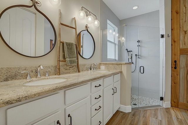 bathroom featuring wood-type flooring, walk in shower, and vanity