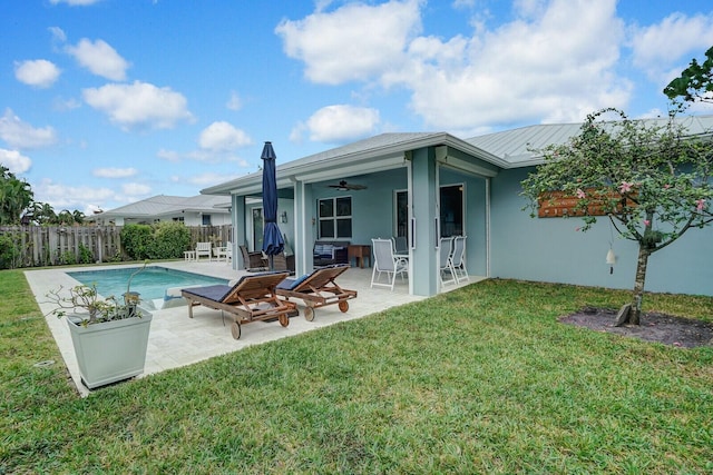 back of house featuring ceiling fan, a yard, a patio area, and a fenced in pool