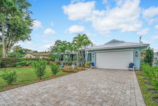 ranch-style house featuring a front lawn and a garage