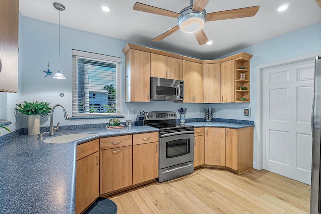 kitchen featuring light hardwood / wood-style floors, sink, hanging light fixtures, and appliances with stainless steel finishes