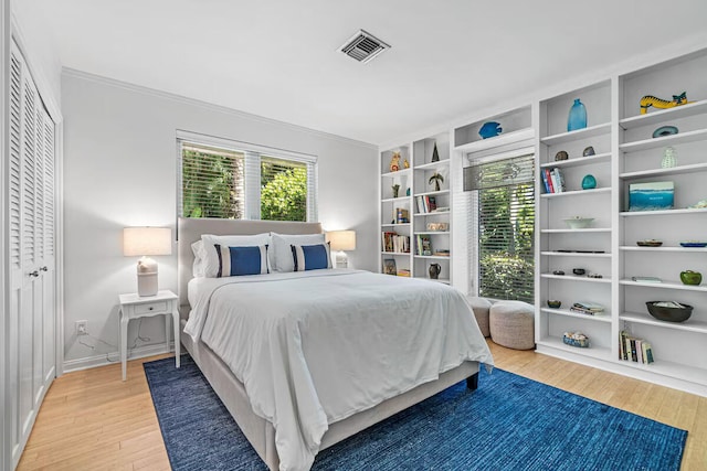 bedroom with hardwood / wood-style flooring, a closet, and multiple windows