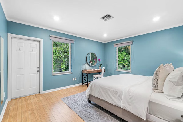 bedroom with light wood-type flooring and crown molding